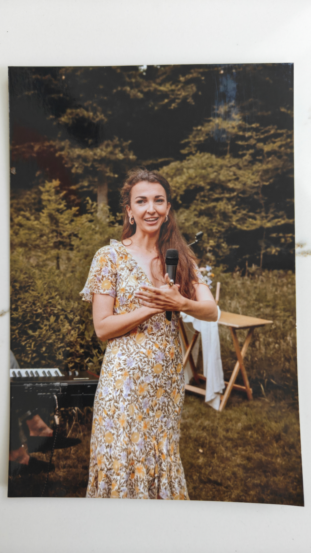Laura speaking, microphone in hand, in a sunlit forest
